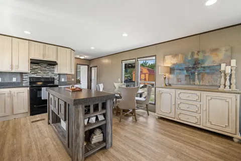 a kitchen with stainless steel appliances granite countertop a stove top oven a sink dishwasher and cabinets with wooden floor