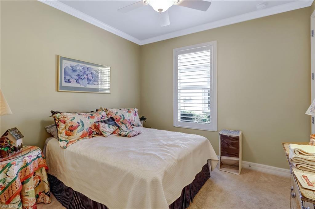 8633 Julia Lane Naples, FL 34114 - Photo 18 of 26 a bedroom with a bed and a chandelier