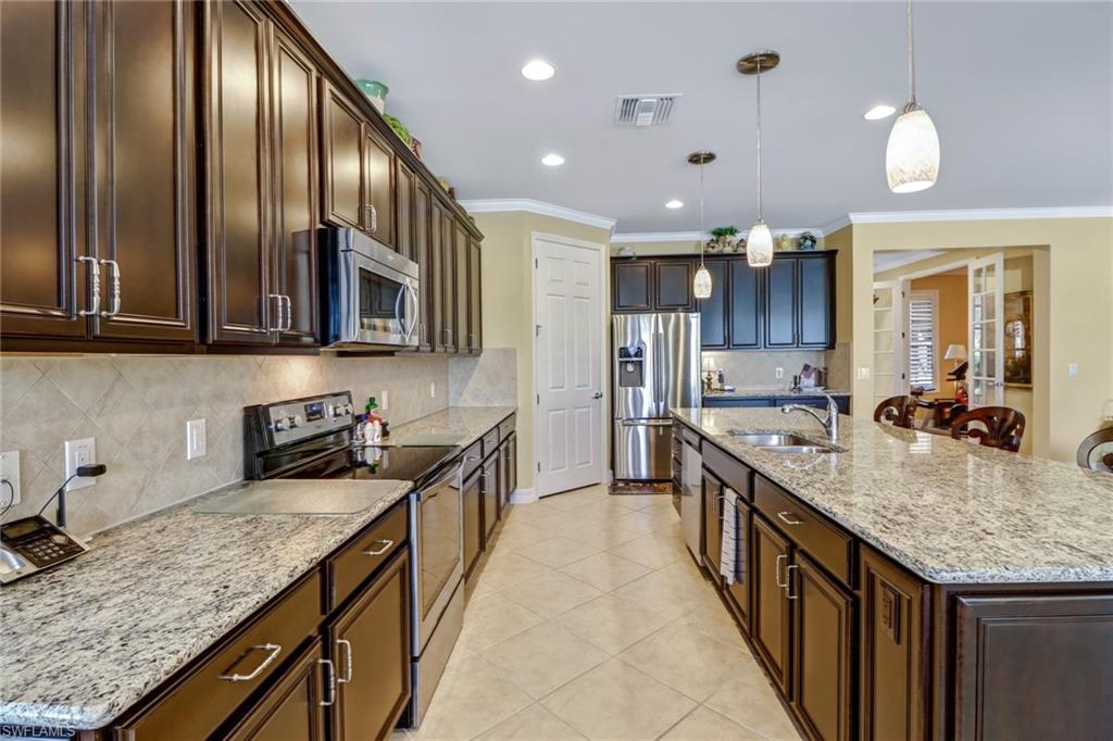 8633 Julia Lane Naples, FL 34114 - Photo 4 of 26 a large kitchen with stainless steel appliances granite countertop a granite counter tops and a view of living room
