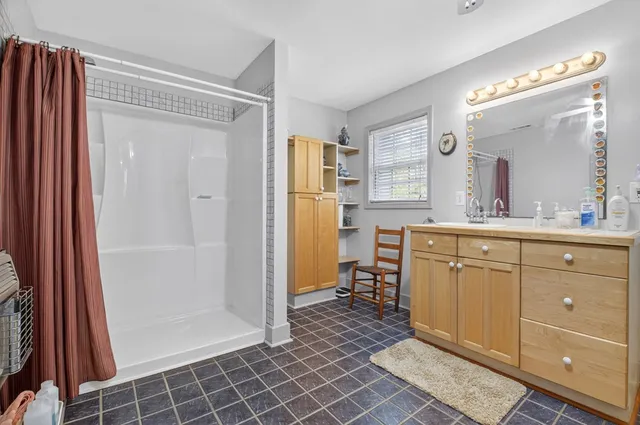a view of a house with a yard and large tree