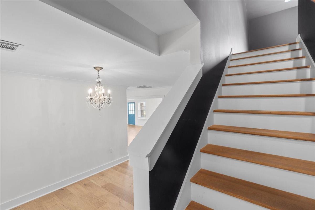 620 Diffee Road Moscow, TN 38057 - Photo 24 of 40 Stairway with wood finished floors and a chandelier