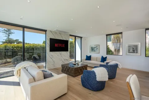 a living room with furniture fireplace and a large window