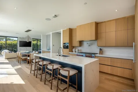 a kitchen with appliances a table and chairs in it