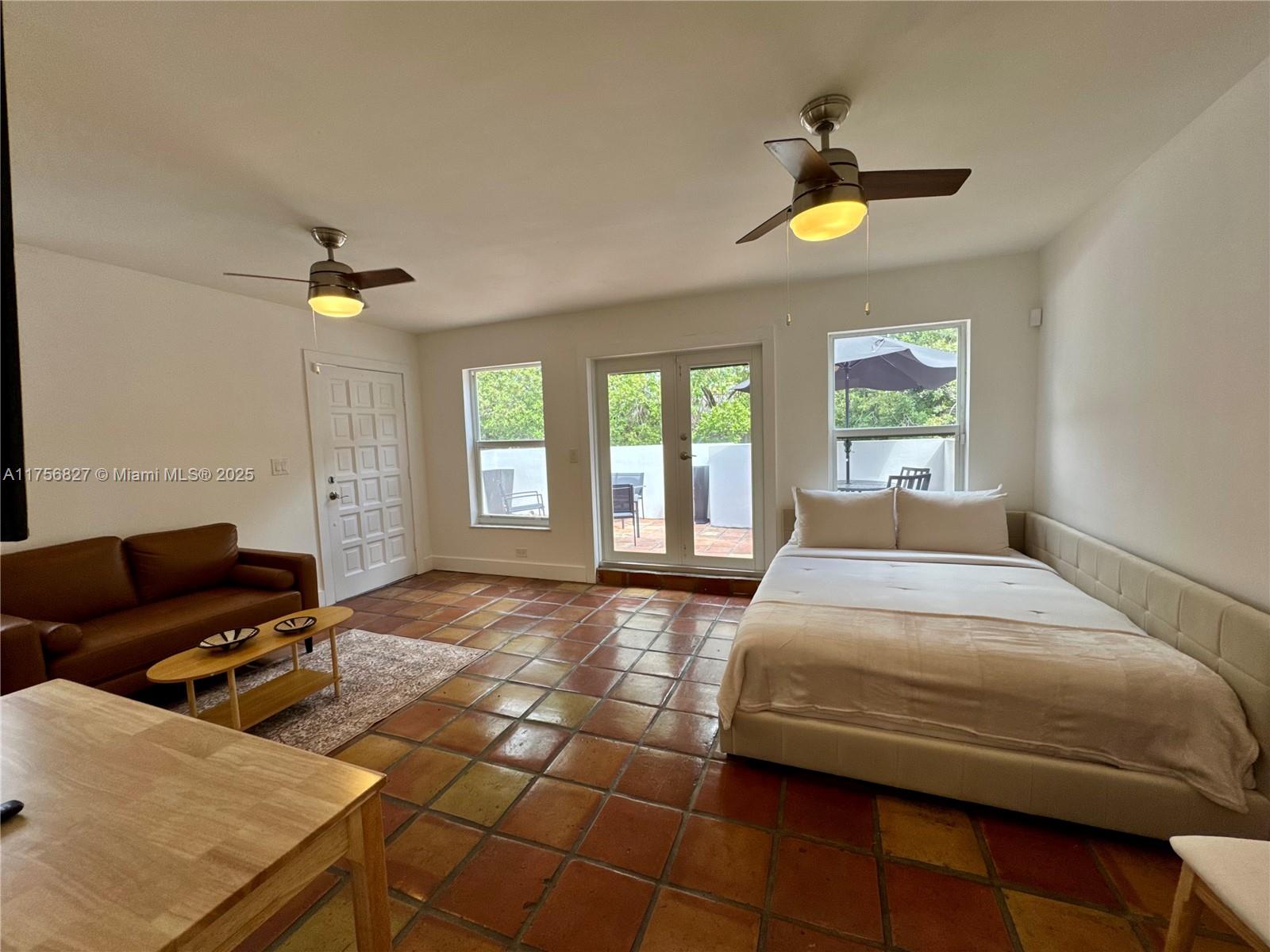 2918 Bird Avenue, Unit 8 Miami, FL 33133 - Photo 2 of 11 a bedroom with a bed and a chandelier