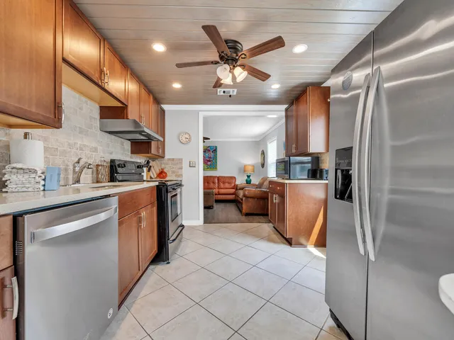a kitchen with stainless steel appliances granite countertop a refrigerator and a sink