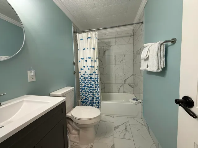 a bathroom with a shower a toilet and sink