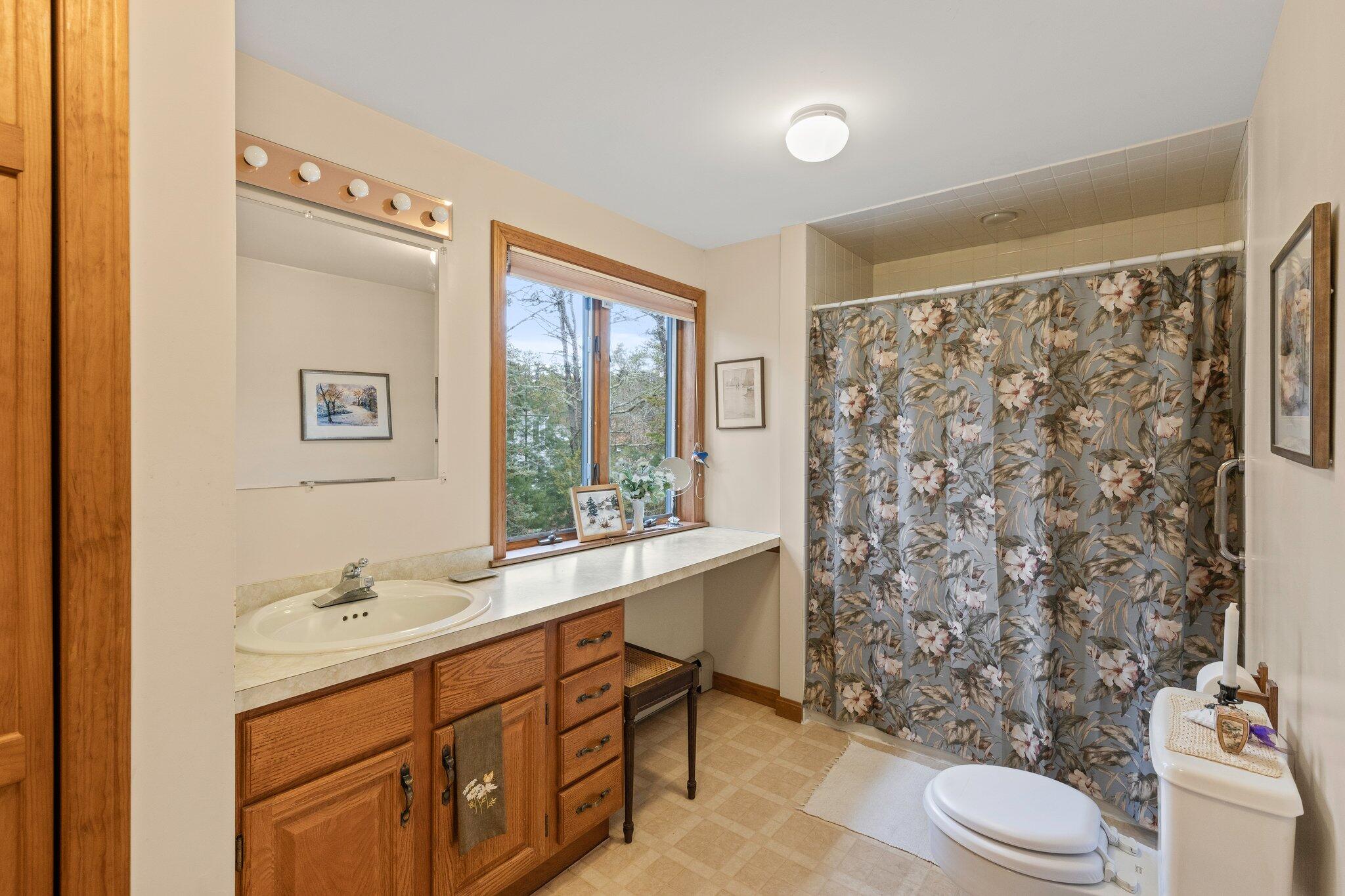 35 Pine Field Road Wellfleet, MA 02667 - Photo 18 of 31 a bathroom with a sink toilet a mirror and shower curtain