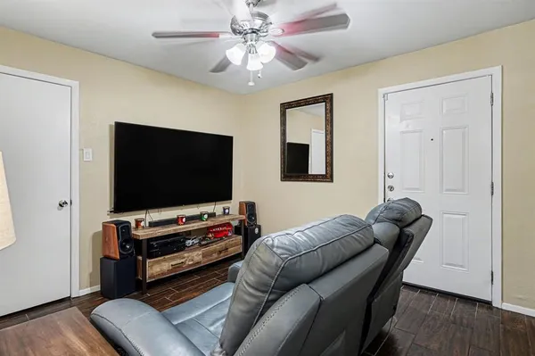 an empty room with wooden floor and a ceiling fan