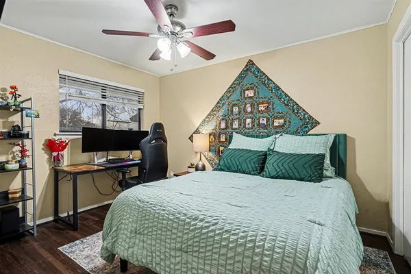 an empty room with wooden floor and ceiling fan