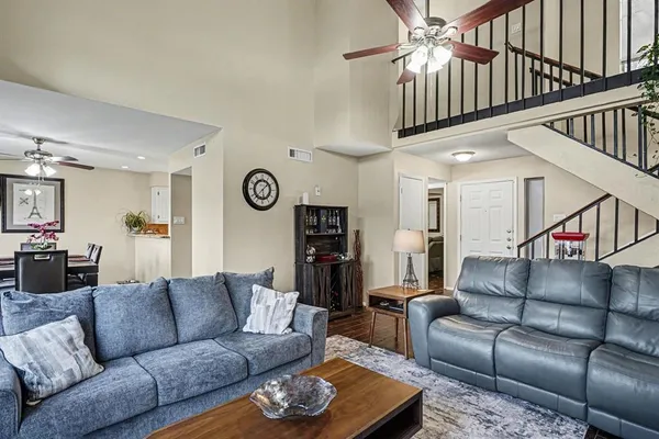a living room with furniture and a ceiling fan