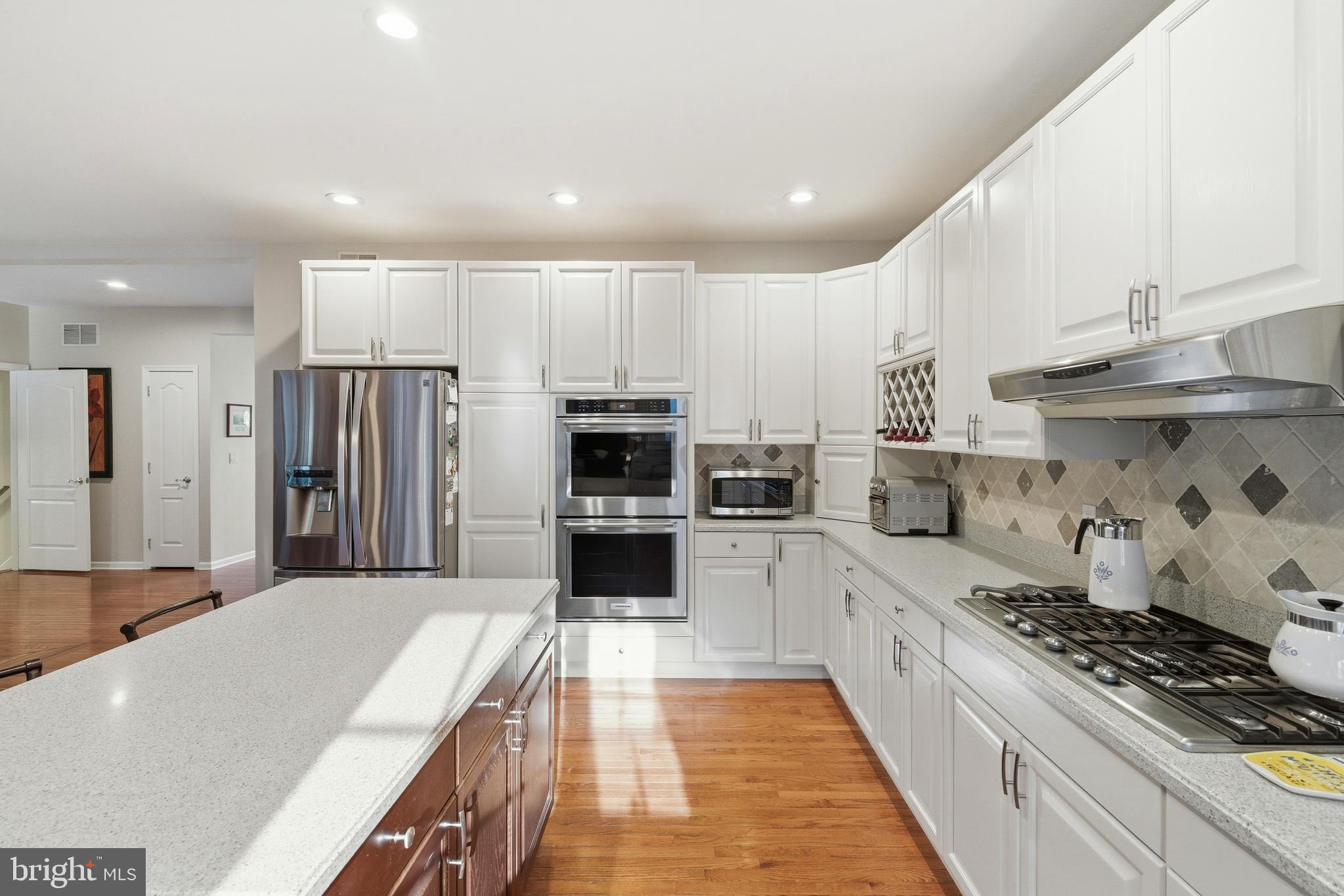 39 Rodeo Drive West Creek, NJ 08092 - Photo 22 of 78 a large kitchen with stainless steel appliances a stove a sink dishwasher and a refrigerator with wooden floor