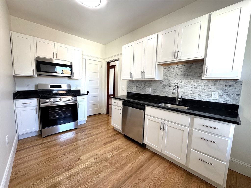 46 Spring Park Avenue, Unit 2 Boston, MA 02130 - Photo 1 of 1 a kitchen with granite countertop a sink a stove and cabinets