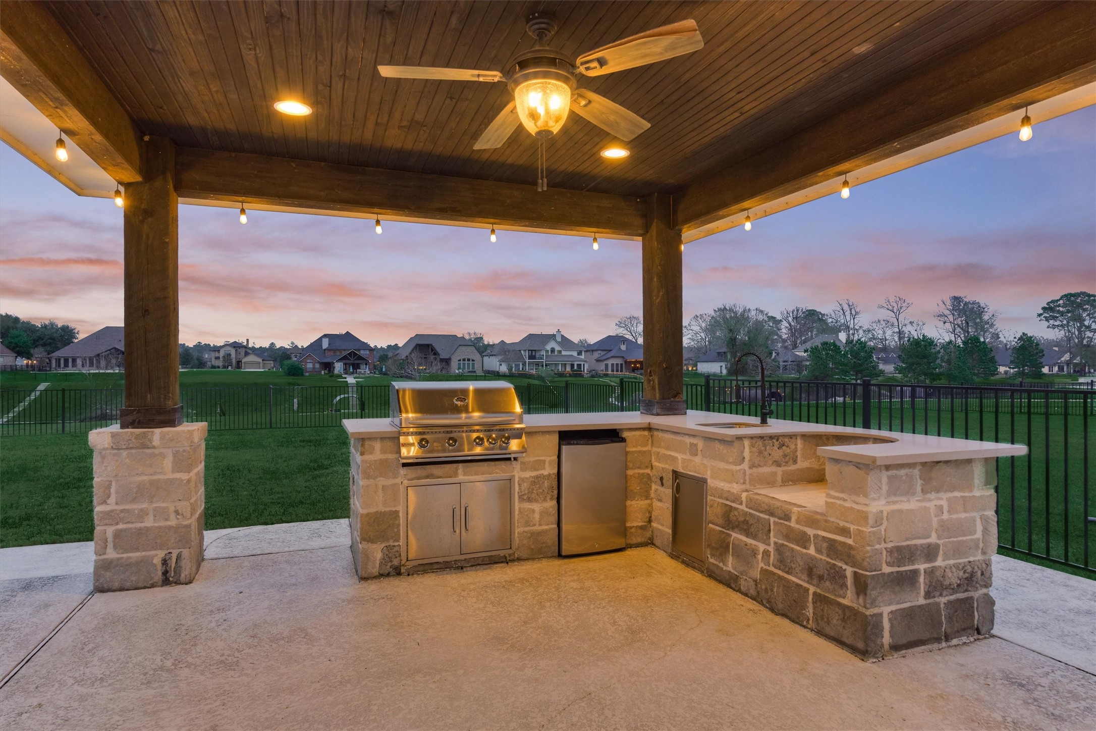 11618 Renaissance Drive Montgomery, TX 77356 - Photo 40 of 49 The outdoor kitchen features a gas grill with storage beneath, beverage refrigerator, sink and nook for a Green Egg smoker, or the like. A stained wood plank ceiling coordinates with the back porch ceiling.
