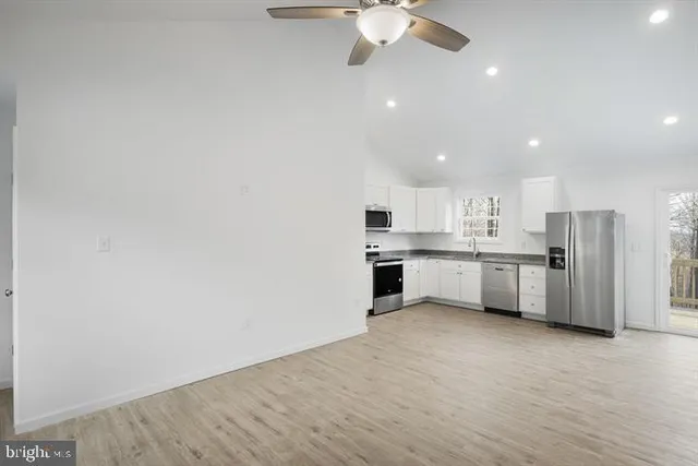 a large white kitchen with a white cabinets and white stainless steel appliances