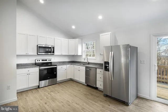 a kitchen with granite countertop stainless steel appliances and wooden cabinets