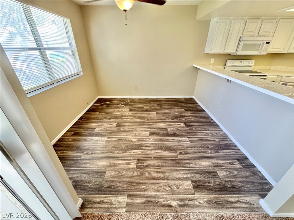 6250 West Flamingo Road, Unit 109 Las Vegas, NV 89103 - Photo 3 of 18 A well-lit breakfast nook with rich wood flooring and a classic ceiling fan.