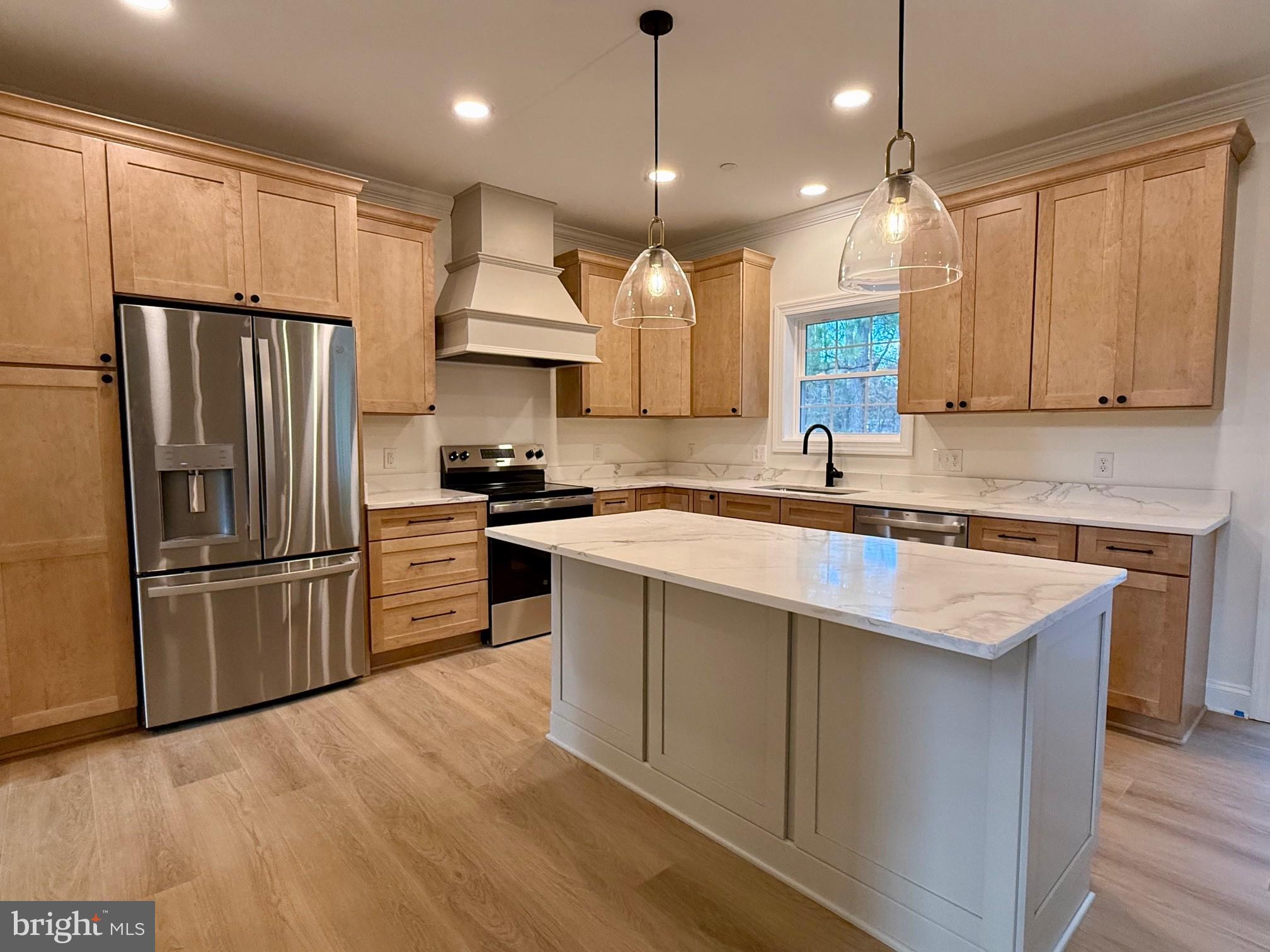 17490 Lighthouse Commons Drive Piney Point, MD 20674 - Photo 16 of 44 a kitchen with kitchen island a counter top space a refrigerator cabinets and wooden floor