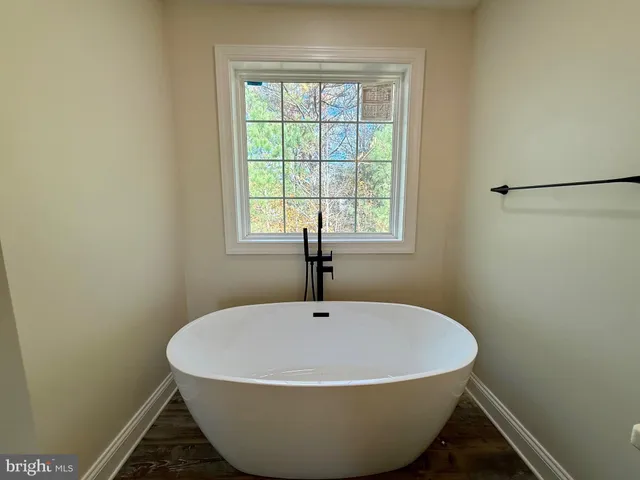 a white bath tub sitting in a bathroom next to a window
