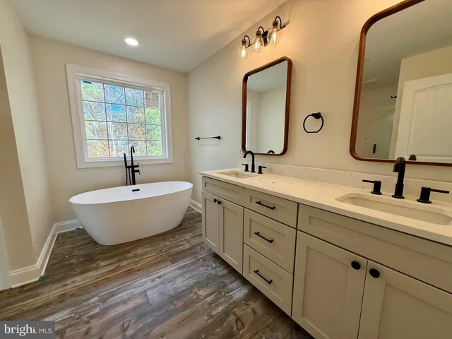 a bathroom with double vanity sinks and a mirror