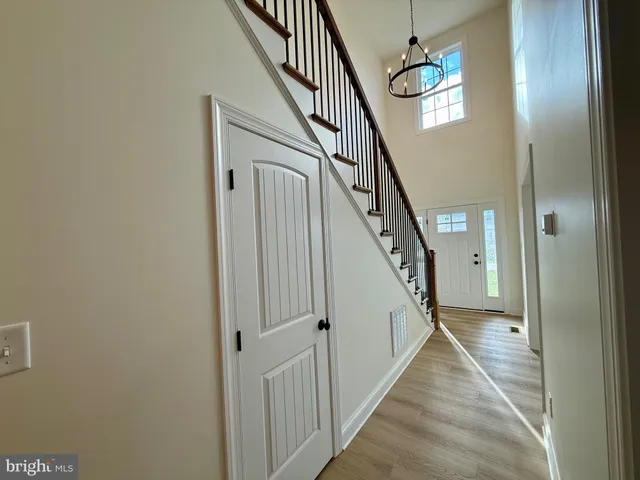 a view of a hallway with wooden floor and stairs