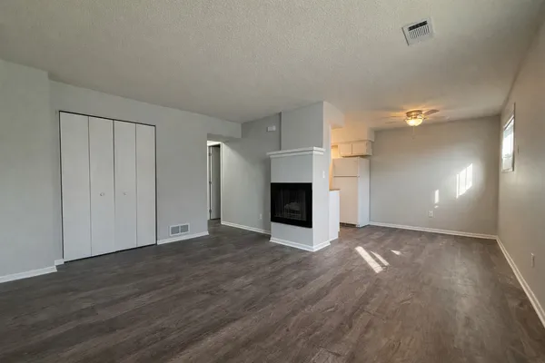 a view of empty room with wooden floor and fireplace