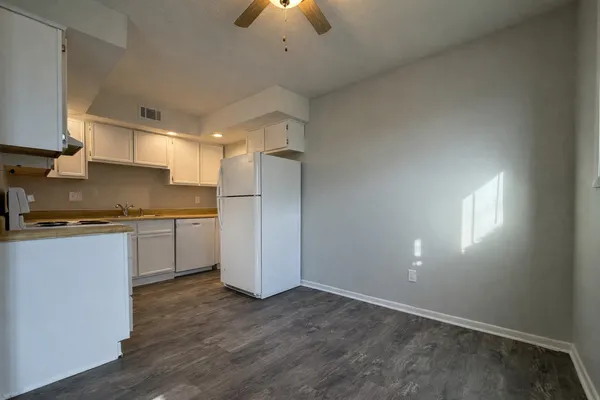 a kitchen with a refrigerator and a stove top oven