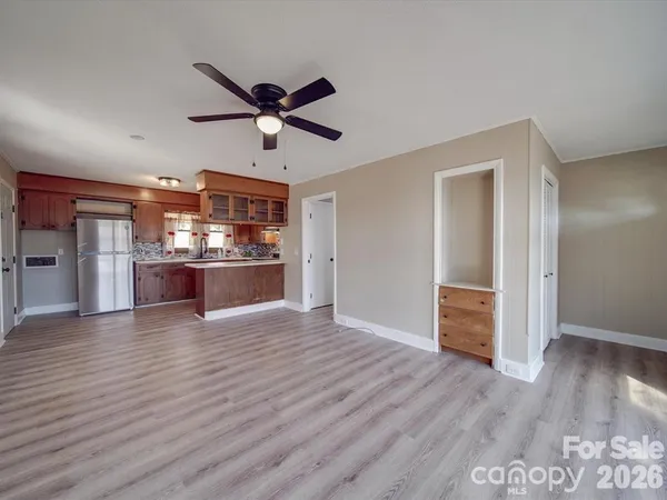 a view of a kitchen with wooden floor and a ceiling fan