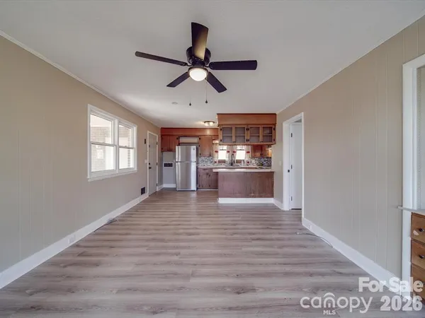 a view of empty room with wooden floor and window