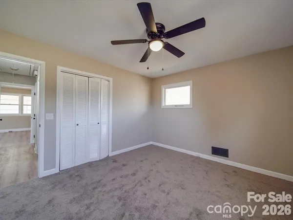 a view of a livingroom with a ceiling fan and window