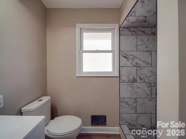 a white toilet sitting next to a window