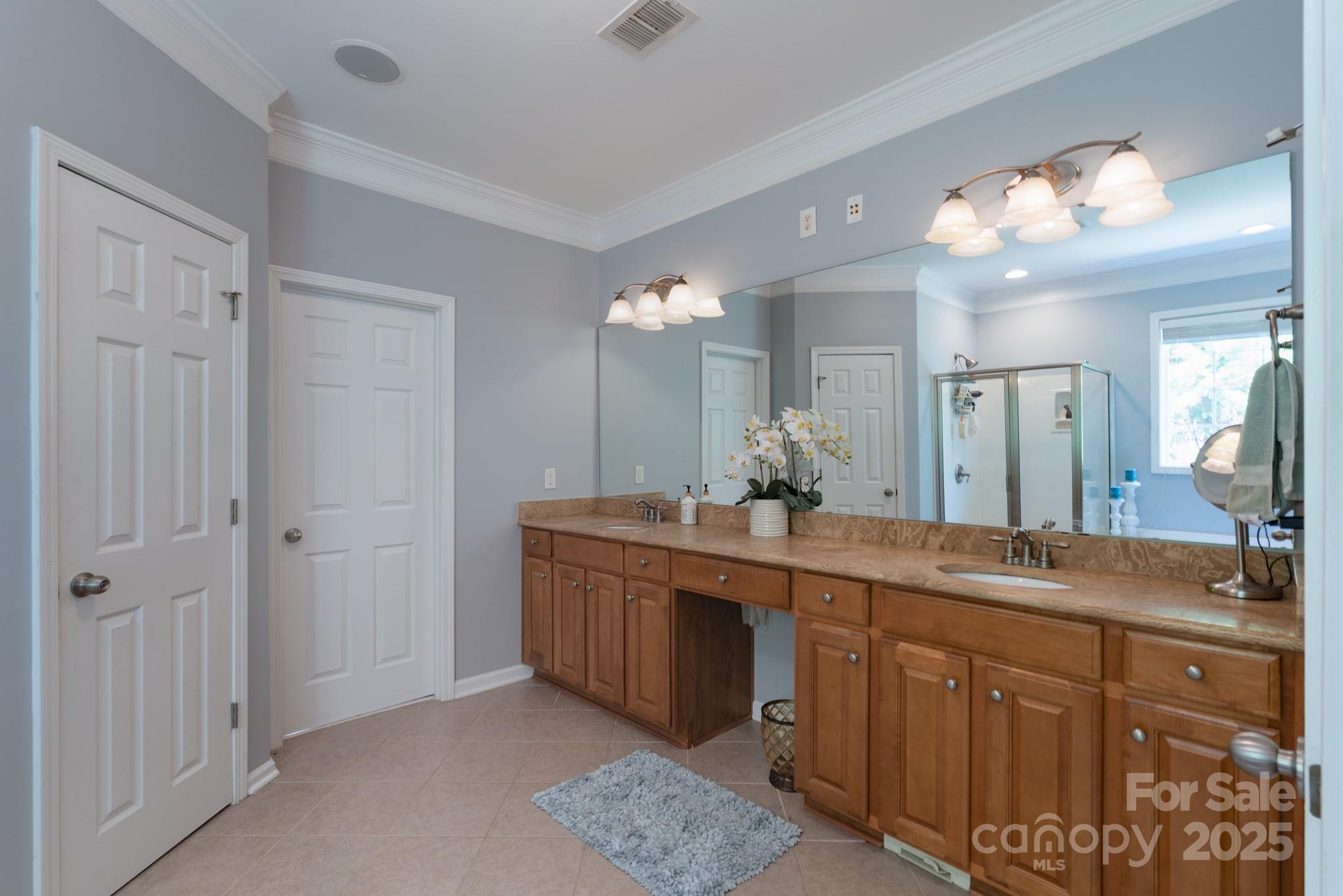 779 Fairway Point Drive Tega Cay, SC 29708 - Photo 23 of 48 a spacious bathroom with a granite countertop sink a mirror and a shower