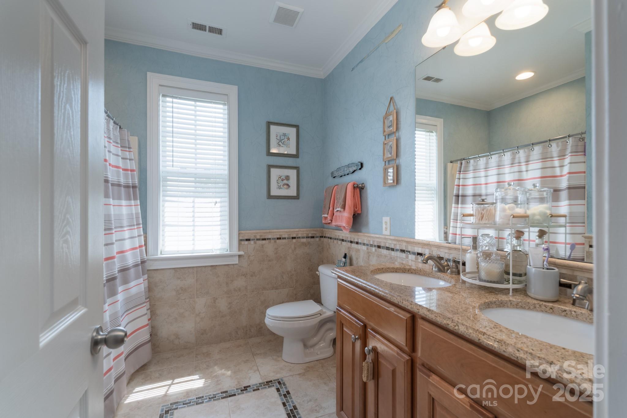 779 Fairway Point Drive Tega Cay, SC 29708 - Photo 24 of 48 a bathroom with a granite countertop double vanity sink a mirror and a toilet