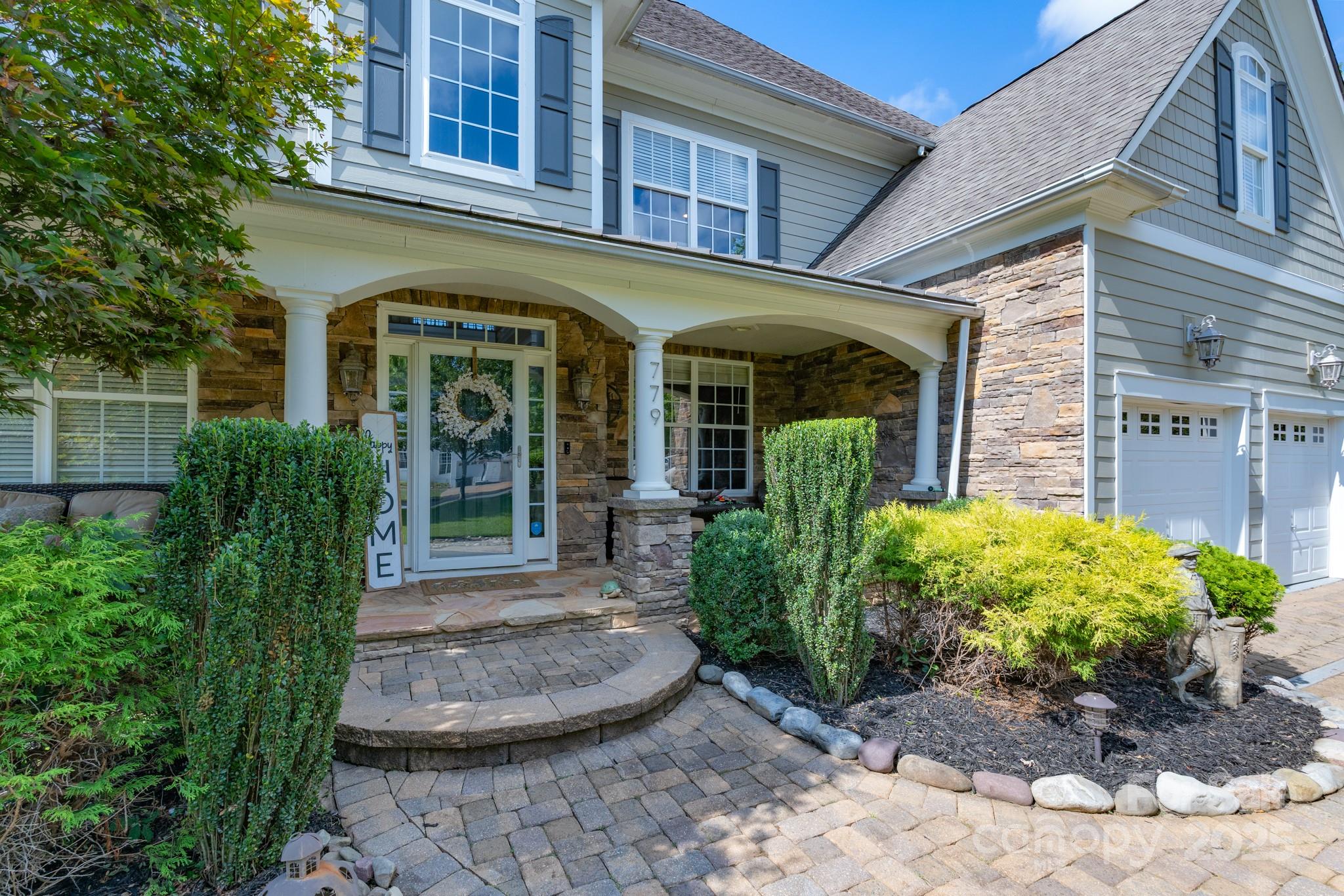 779 Fairway Point Drive Tega Cay, SC 29708 - Photo 3 of 48 a front view of a house with garden