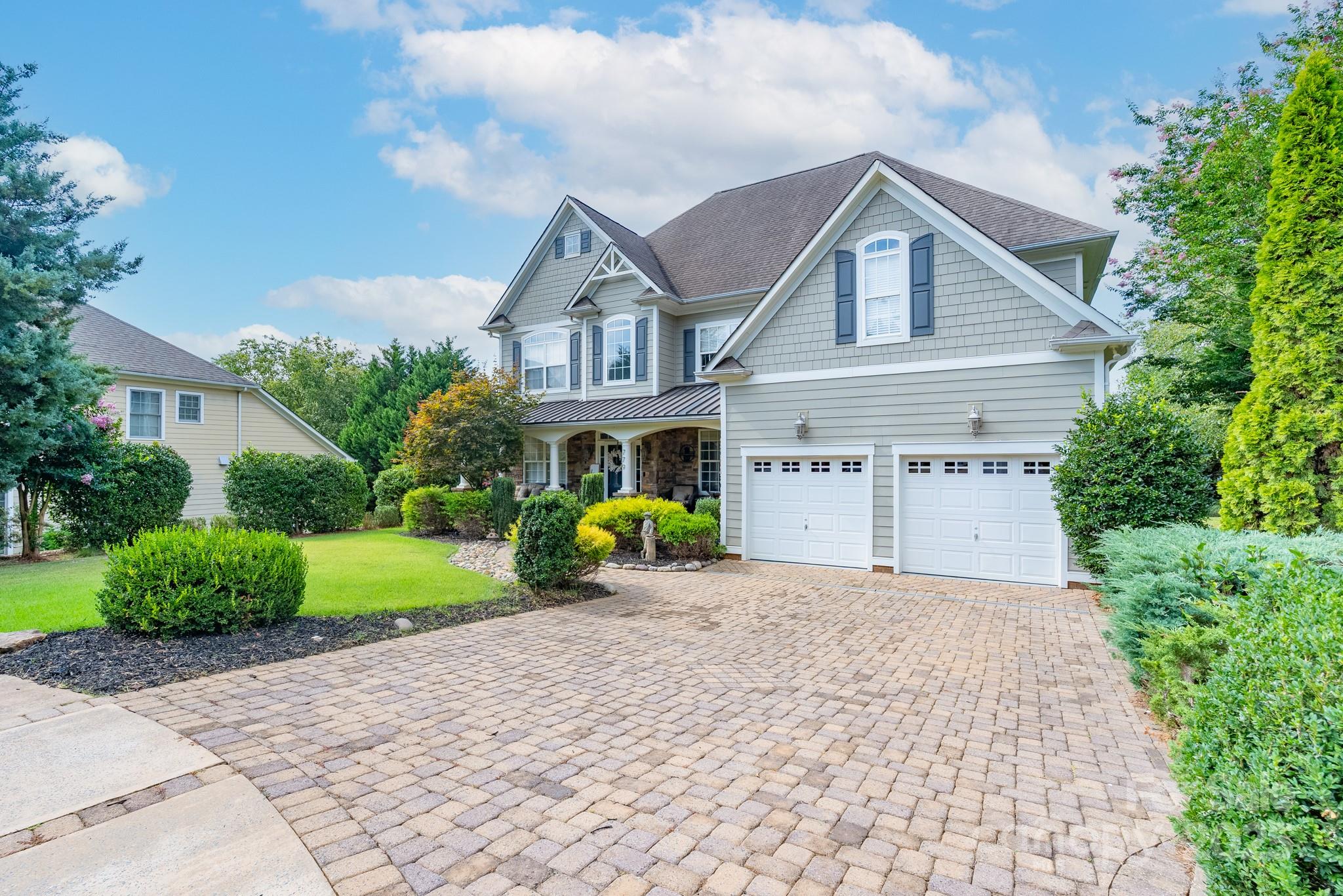 779 Fairway Point Drive Tega Cay, SC 29708 - Photo 4 of 48 a front view of a house with garden and porch