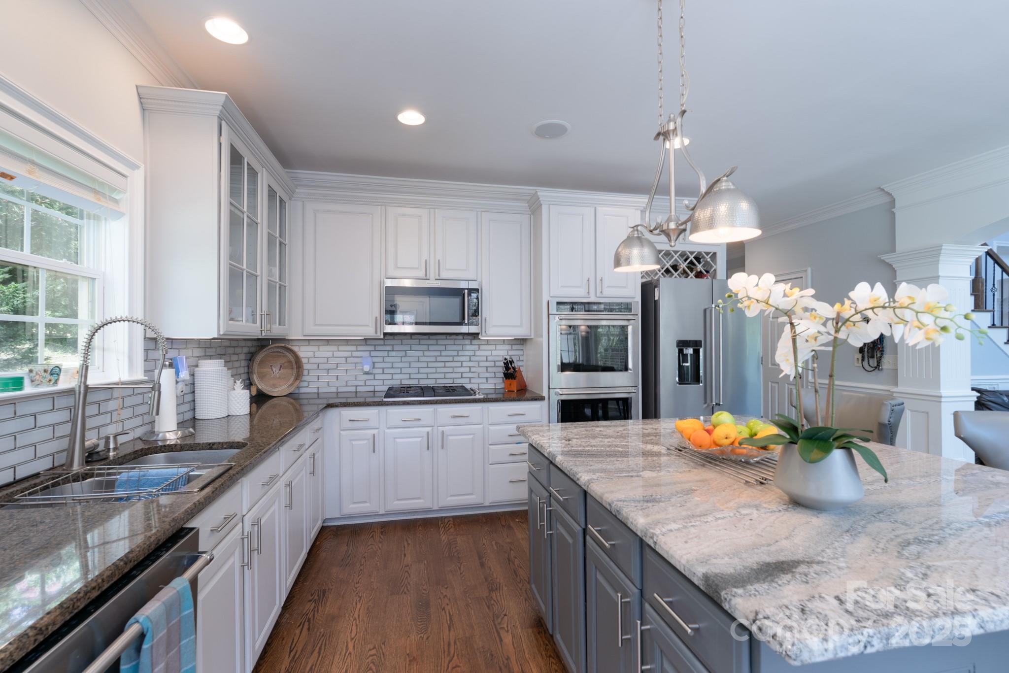 779 Fairway Point Drive Tega Cay, SC 29708 - Photo 10 of 48 a large kitchen with granite countertop a sink stove and cabinets