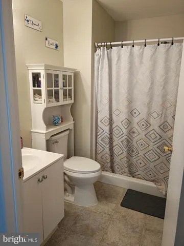 a bathroom with a sink a toilet and shower curtain