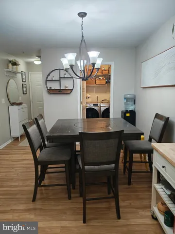 a view of a dining room with furniture a chandelier and wooden floor