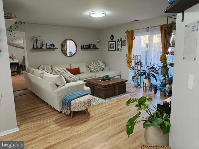 a living room with patio furniture and a wooden floor