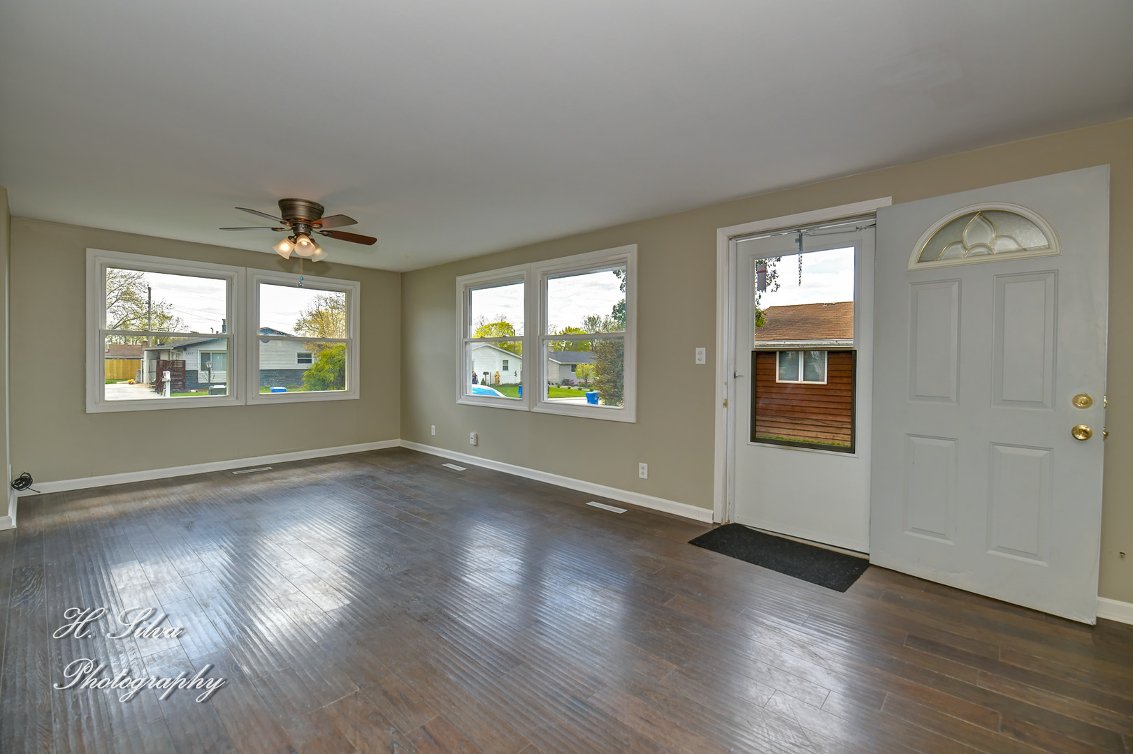 1516 Pawnee Road Carpentersville, IL 60110 - Photo 2 of 12 an empty room with wooden floor chandelier and windows