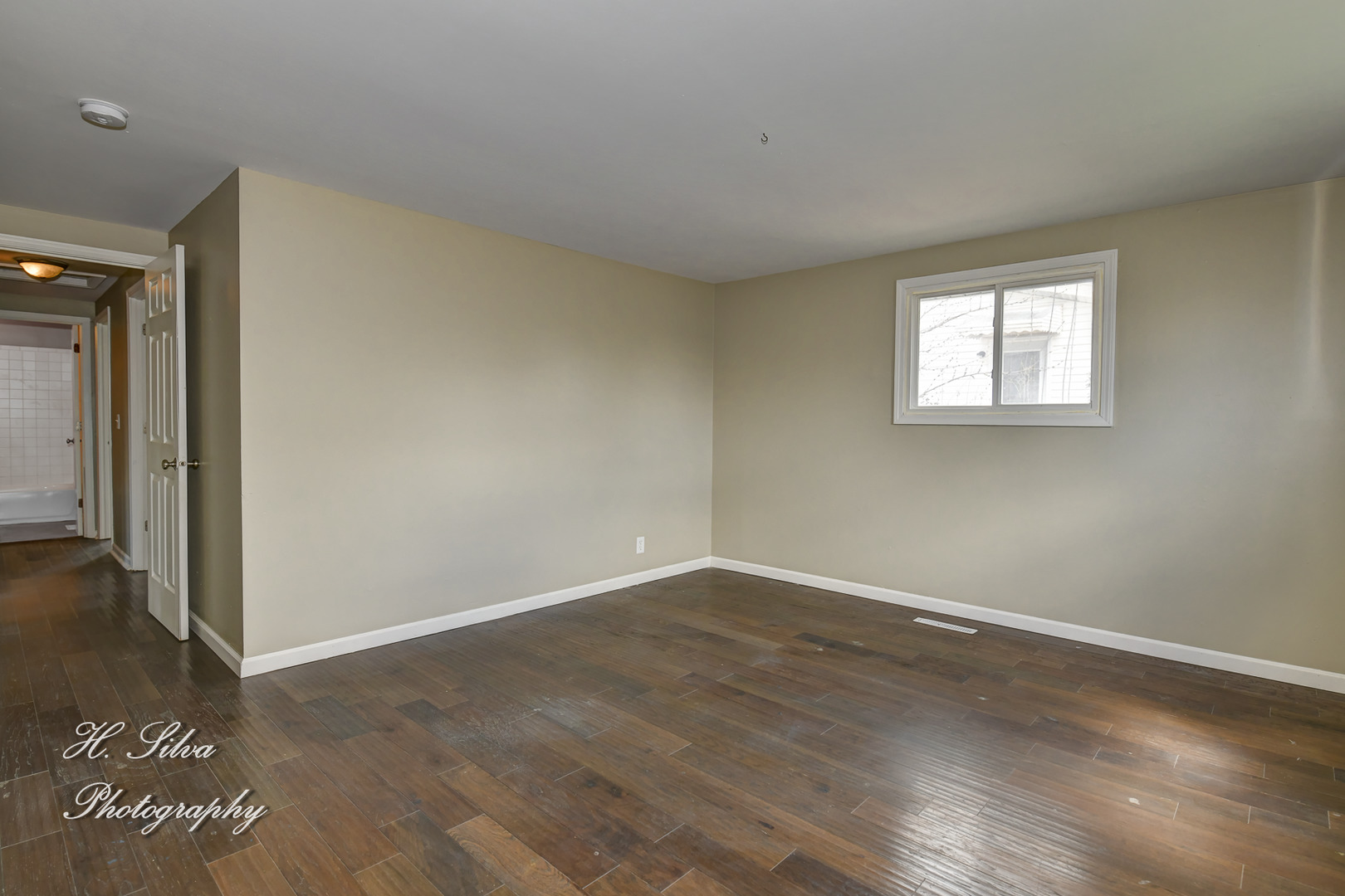 1516 Pawnee Road Carpentersville, IL 60110 - Photo 7 of 12 an empty room with wooden floor and windows