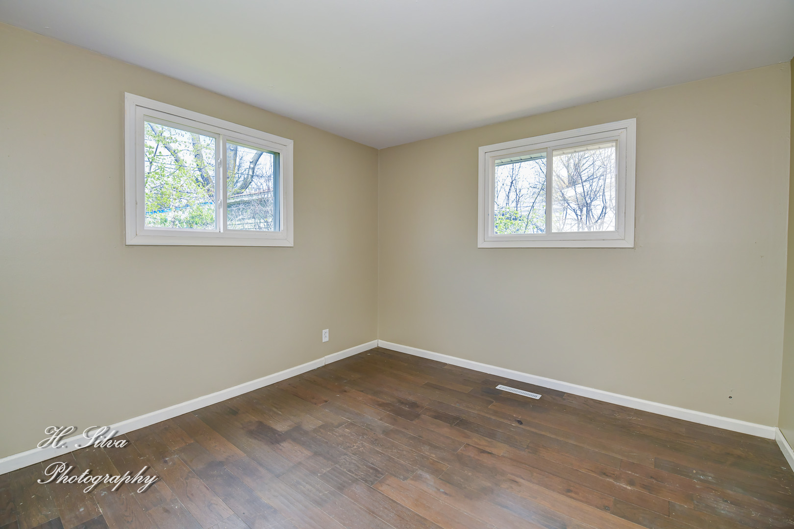 1516 Pawnee Road Carpentersville, IL 60110 - Photo 8 of 12 a view of an empty room with wooden floor and a window