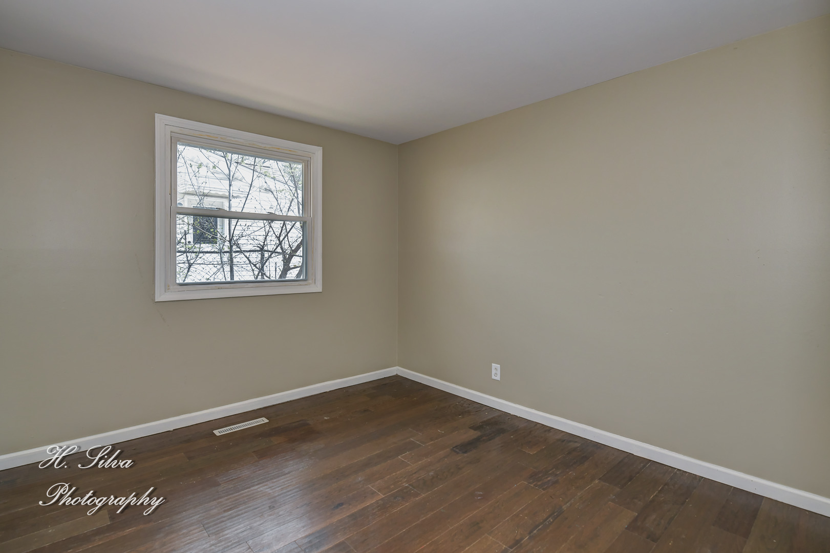 1516 Pawnee Road Carpentersville, IL 60110 - Photo 9 of 12 a view of an empty room with wooden floor and a window