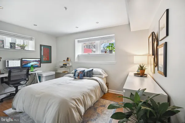 a bedroom with two beds and a desk next to a window