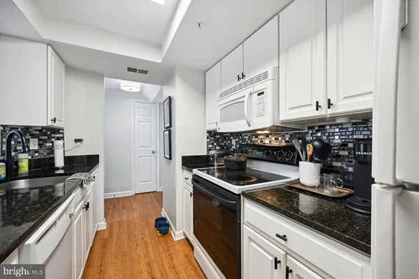 a kitchen with granite countertop a stove and cabinets