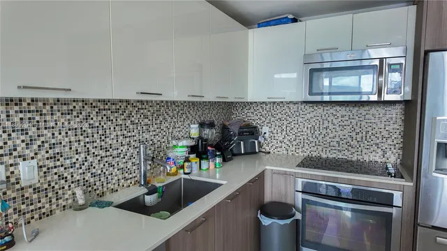 a kitchen with a sink and a stove top oven