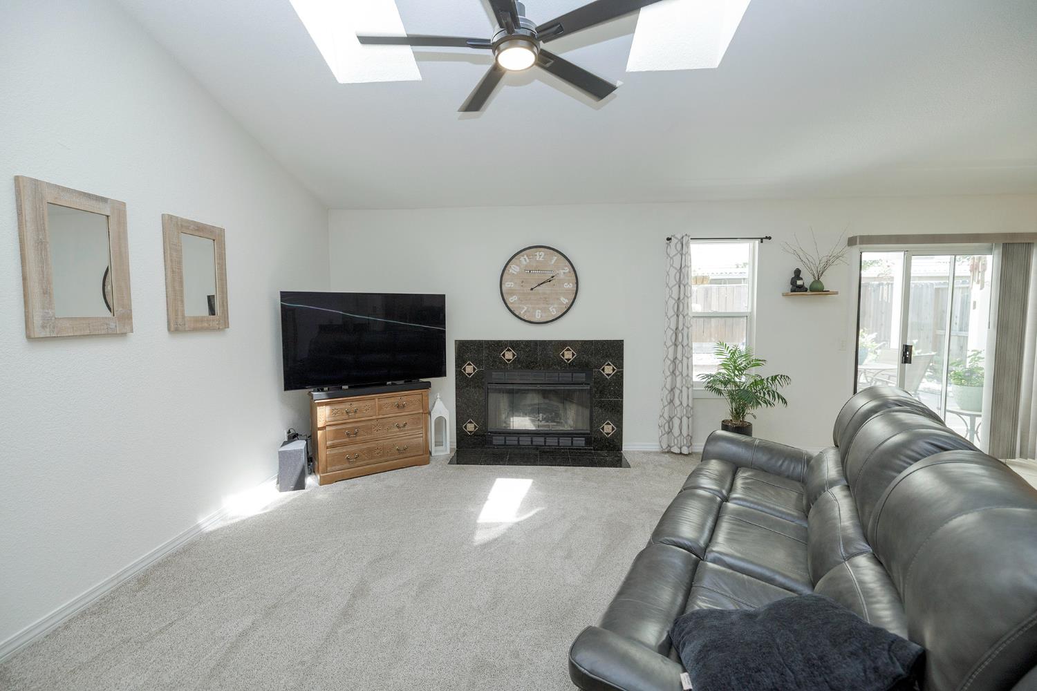 230 Meyenberg Avenue Ripon, CA 95366 - Photo 14 of 52 a living room with furniture a flat screen tv and a fireplace