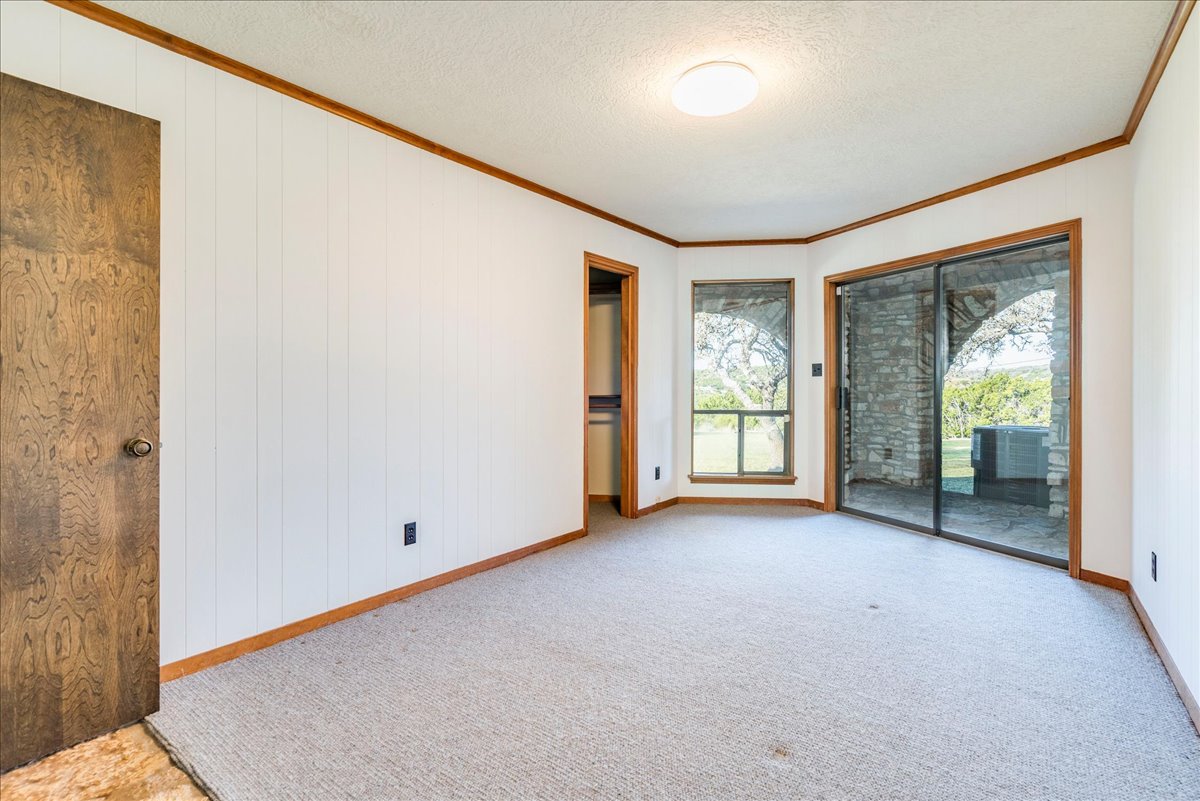 9763 Ranch Road 1623 Blanco, TX 78606 - Photo 24 of 40 Carpeted interior space featuring white vertical paneling and wood trim