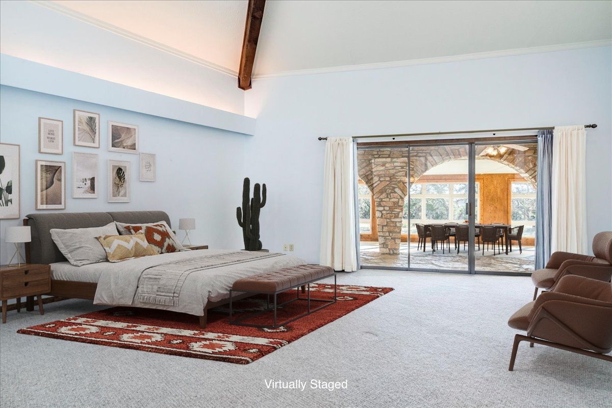 9763 Ranch Road 1623 Blanco, TX 78606 - Photo 25 of 40 a spacious bedroom with a bed a couch and large window