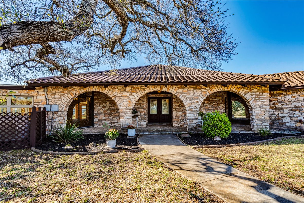 9763 Ranch Road 1623 Blanco, TX 78606 - Photo 5 of 40 a front view of a house with garden