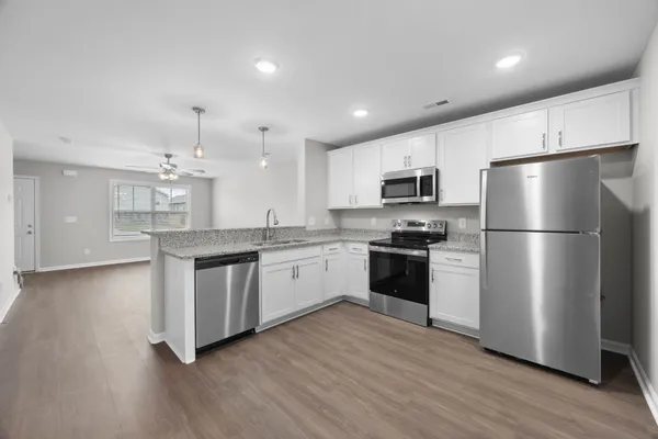 a kitchen with a refrigerator and a stove top oven